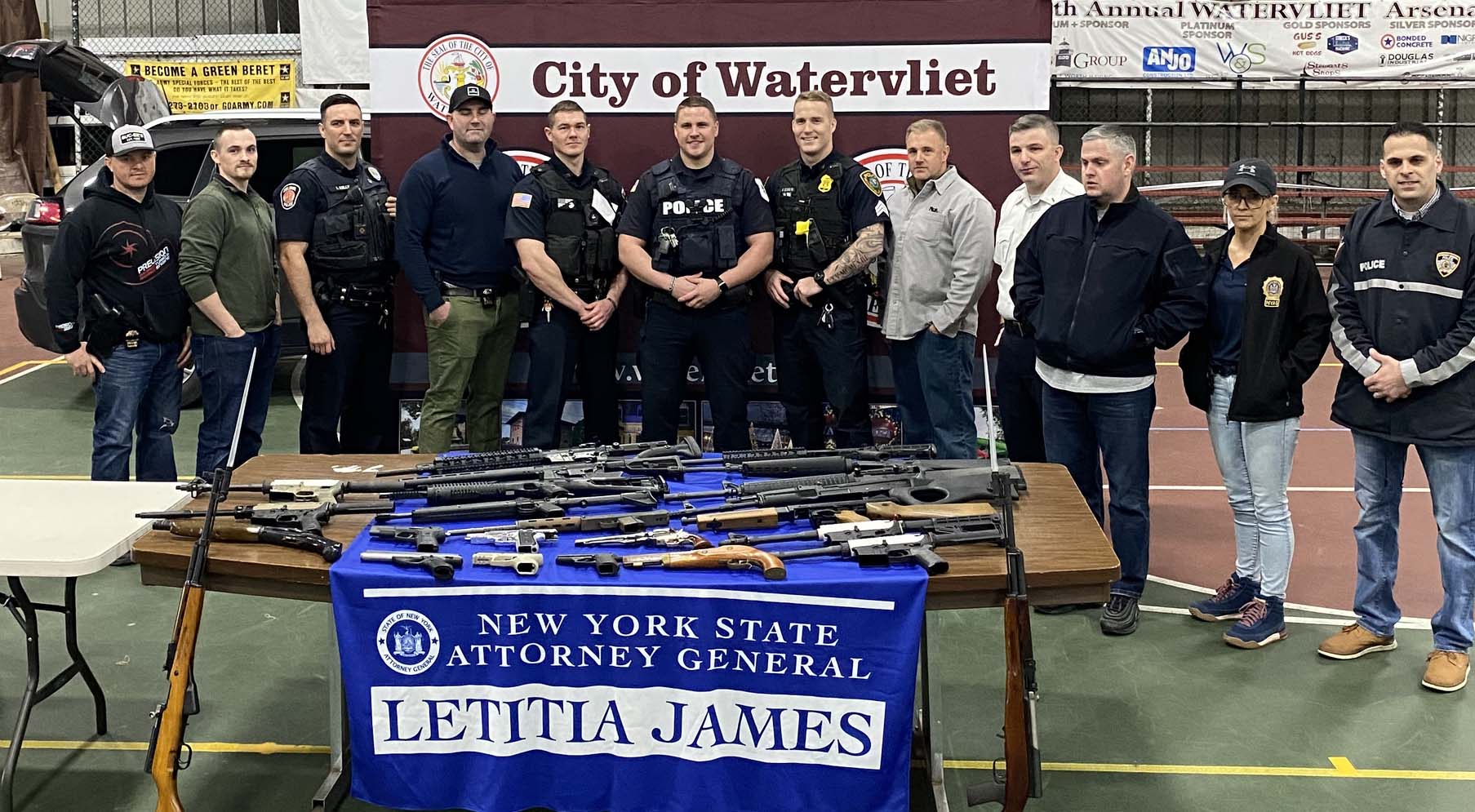 several guns on a blue tablecloth with the text New York State Attorney General Letitia James