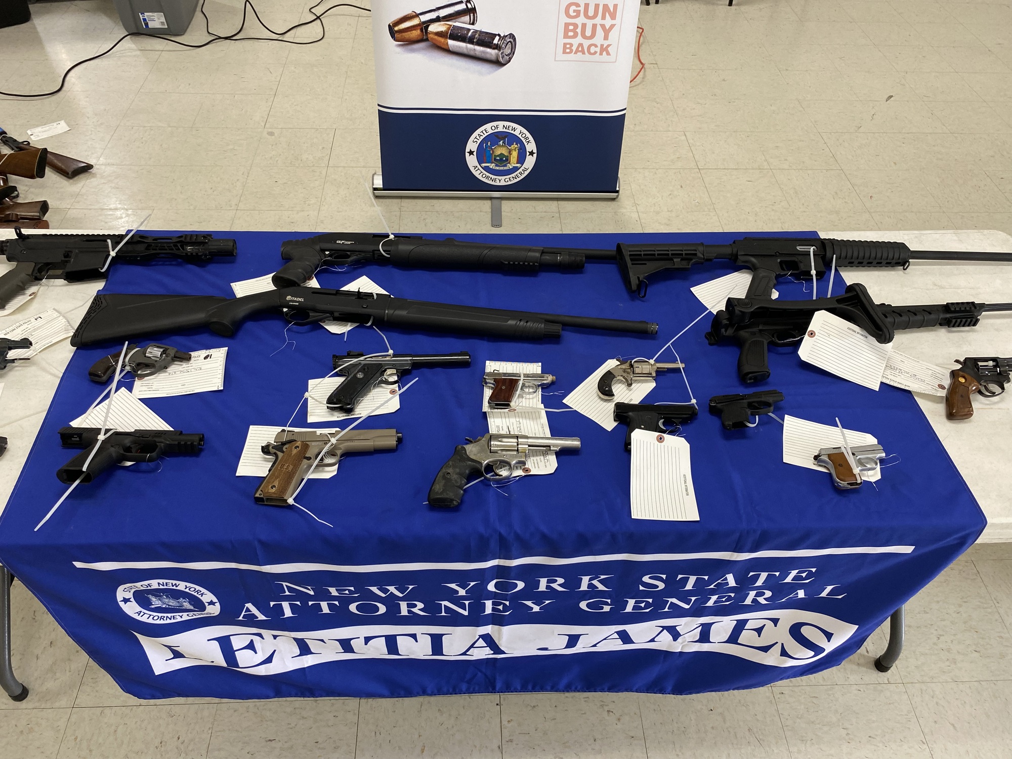 Table with a dozen firearms laying on it
