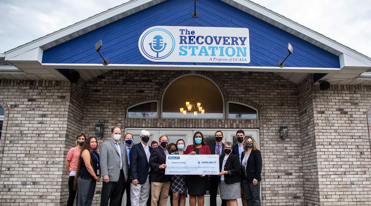 Tish James on the HEAL NY opioid tour in Batavia, standing in front of The Recover Station and holding a check. 