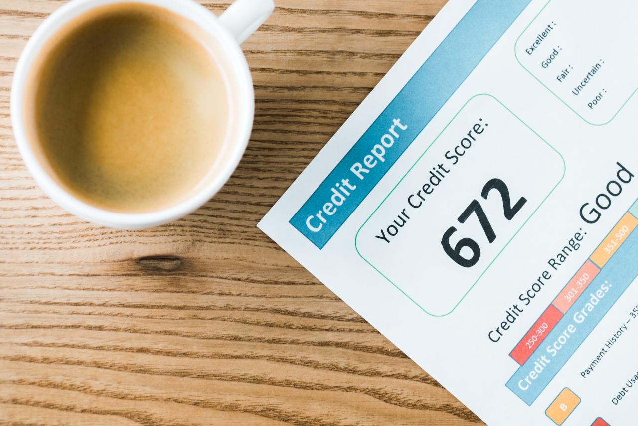 An image of a coffee cup placed next to a paper with a credit score report of 672