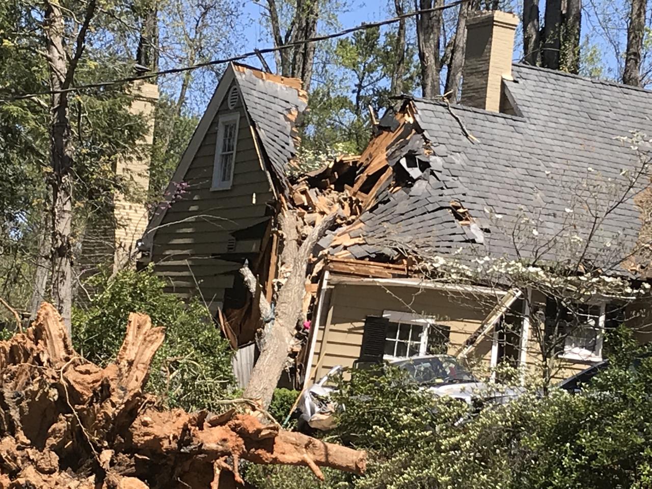 Una imagen de una casa destruida debido a que un árbol cayó en el techo y la pared lateral