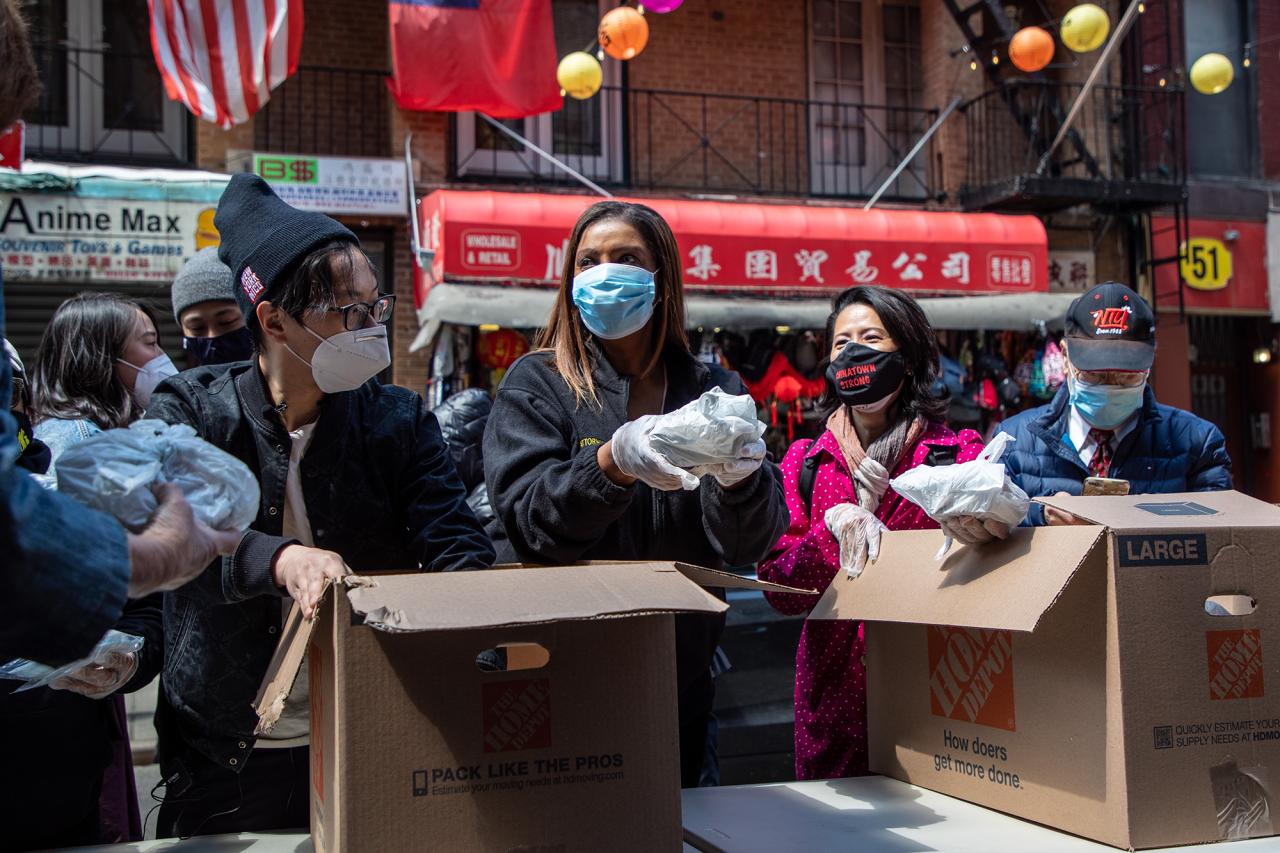 AG James volunteers at a food drive in Chinatown, NYC. She is seen here helping distribute food from donation boxes. 