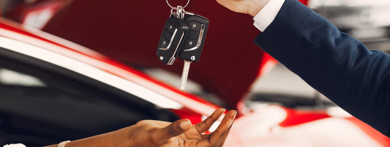 Person dropping car keys into another's hand