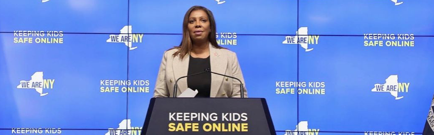 詹姆斯总检察长站在讲台上，手举 "保护儿童上网安全 "的标牌