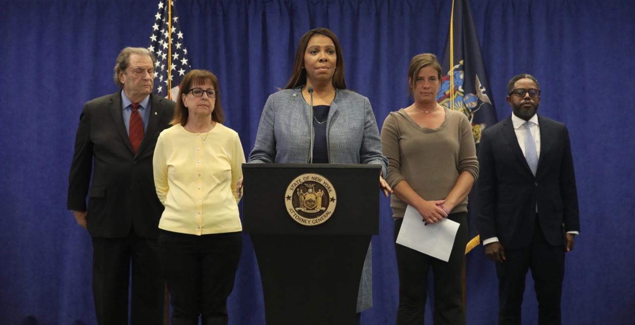 AG James standing at a podium with individuals behind her