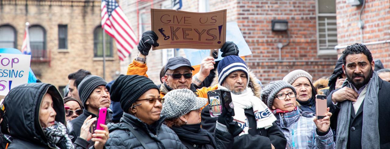 group of tenants with a sign that reads give us our keys