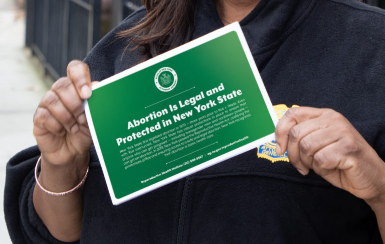 AG James holding abortion rights card