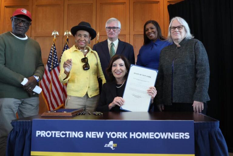 Ny Gov. Kathy Hochul and AG James and other holding signed bill