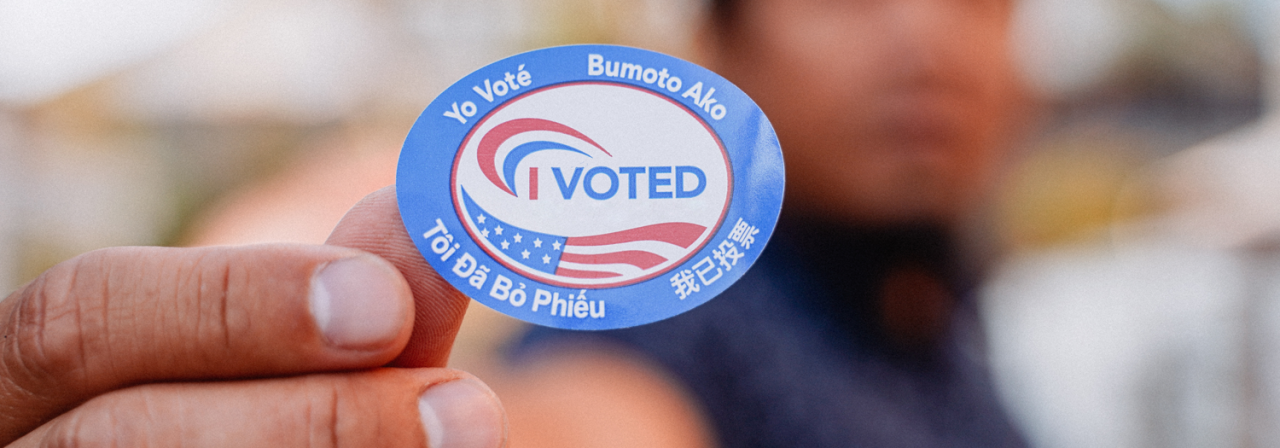 Person holding out 'I voted' sticker