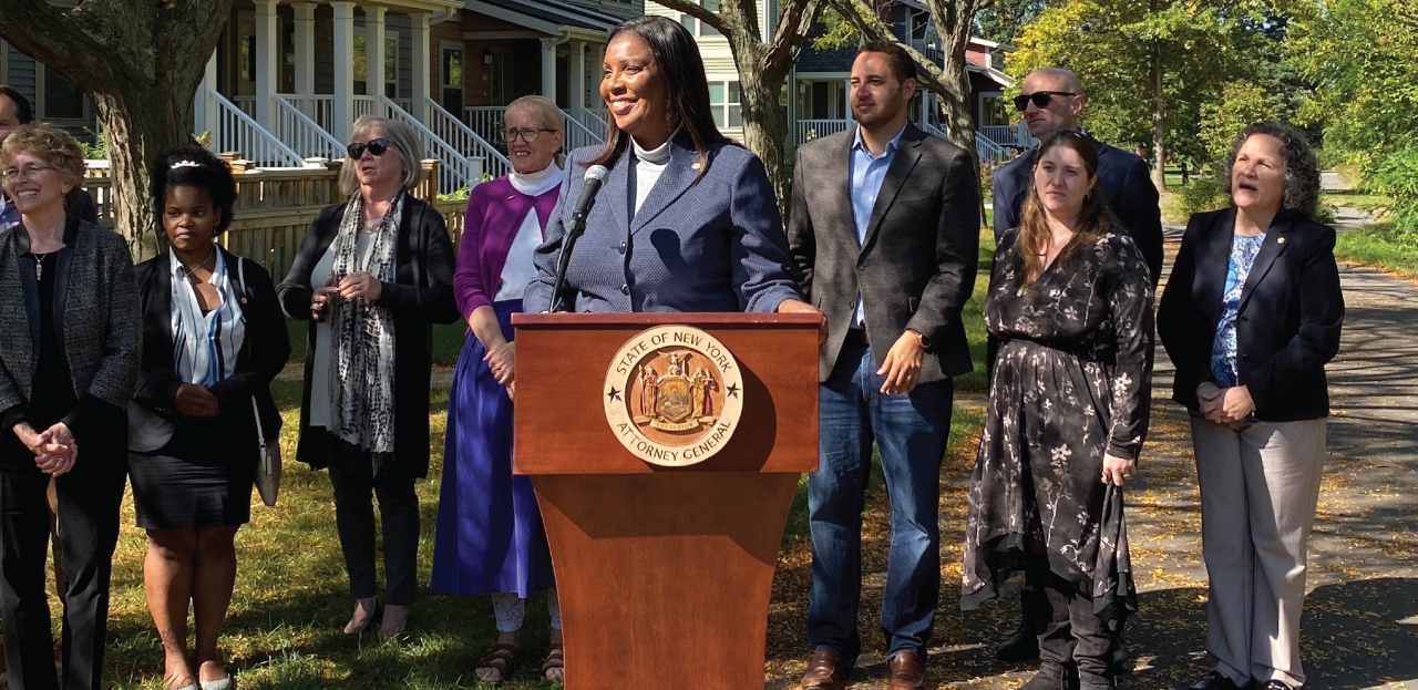 AG James behind podium with others