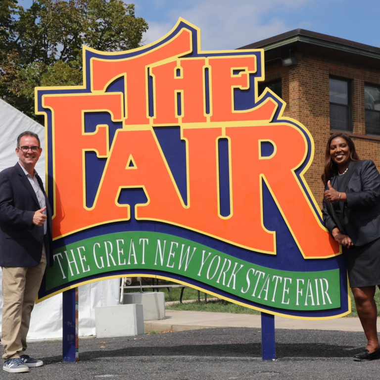 AG James in front of NYS fair sign