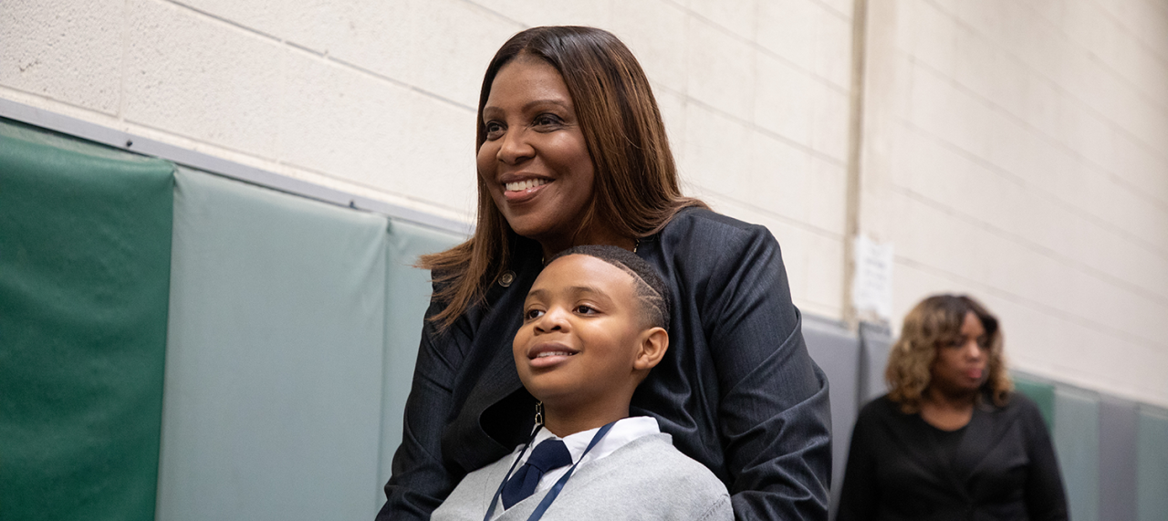 AG James posing for a picture with a little boy