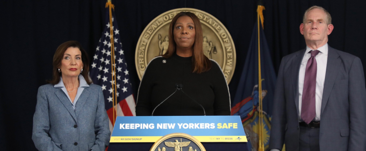 AG James at a podium with a sign that reads Keeping New Yorkers SAFE