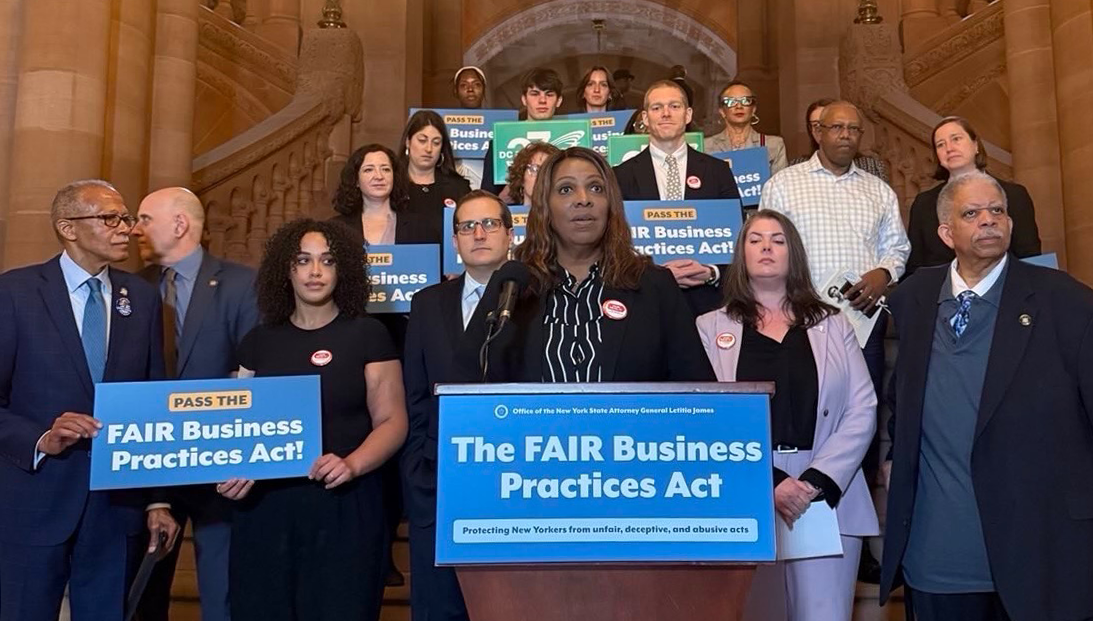 AG James at a podium with a group of people behind her