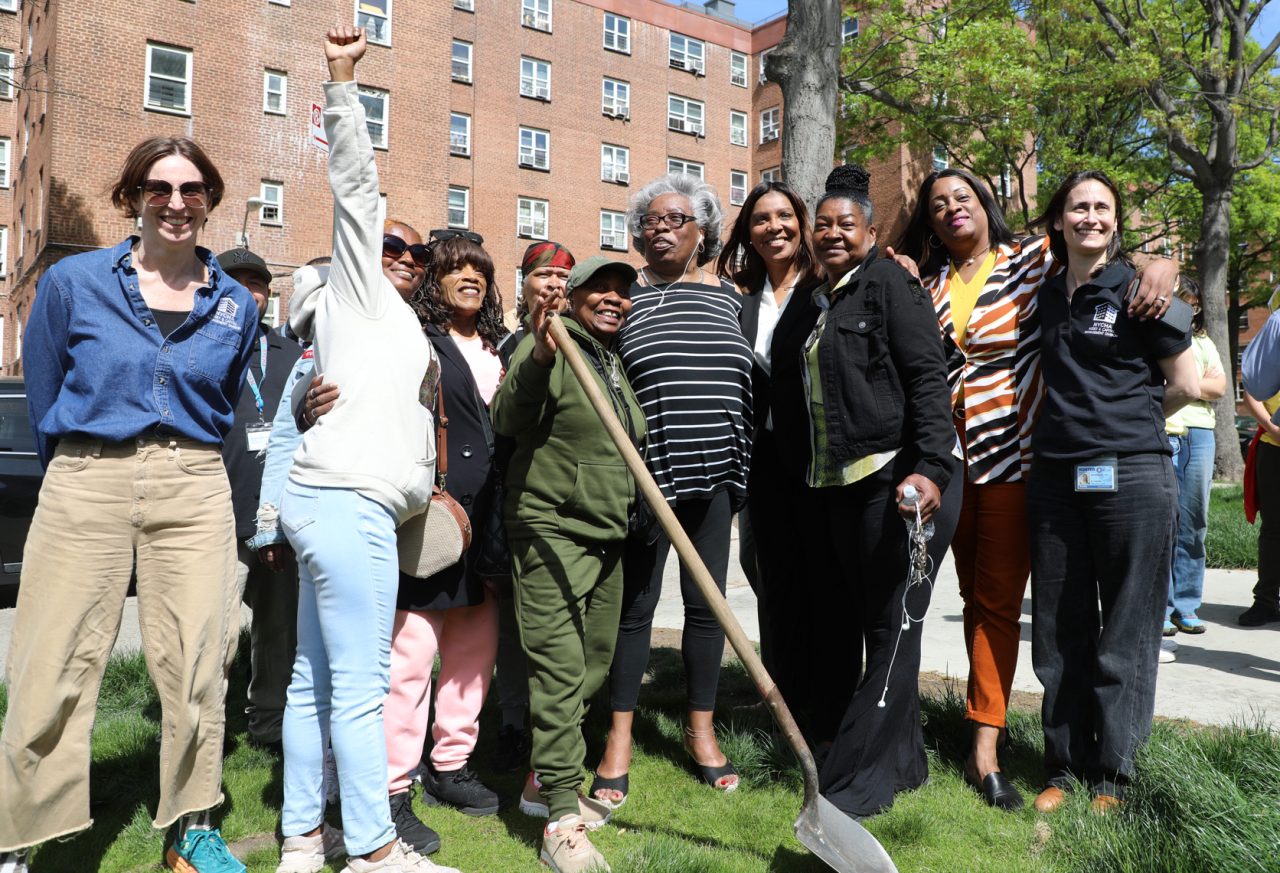 AG James with a group of people holding a shovel