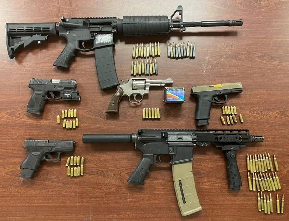 Assault rifles, ghost guns, ammunition, and a high-capacity magazine recovered by the investigation