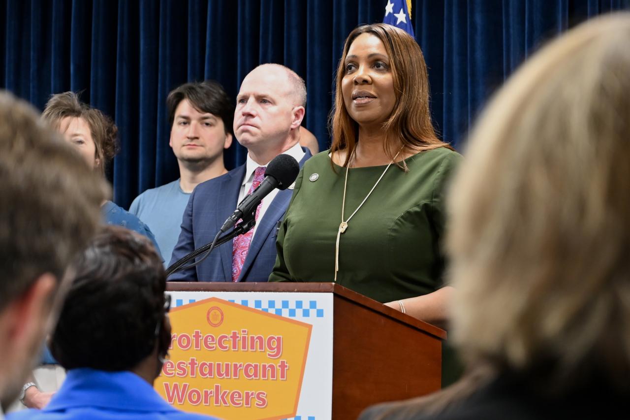 Attorney General James at a podium with a group of people and a sign that reads "Protecting restaurant workers"